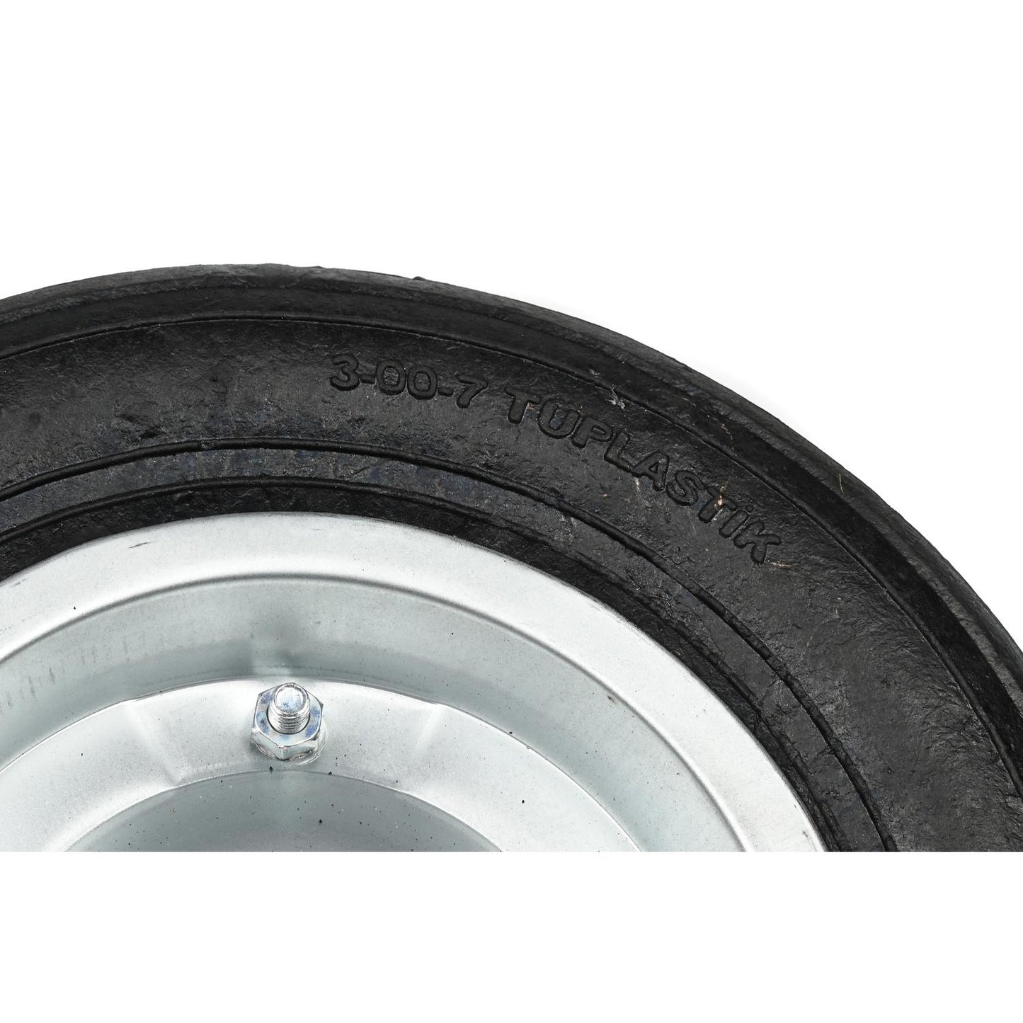 Nahaufnahme eines Abschnitts eines schwarzen Reifens auf weißem Hintergrund. Zu sehen ist die eingeprägte Aufschrift „3-00-7 TUPLASTIK“ auf der Gummilauffläche sowie ein Teil der silbernen Metallfelge mit einer Schraube