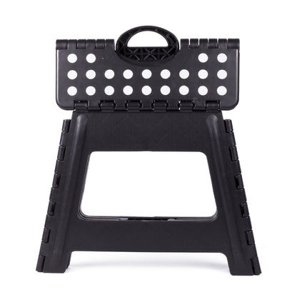 Schwarzer Klapphocker mit weißen Punkten auf der Sitzfläche, vollständig zusammengeklappt und frontal stehend auf weißem Hintergrund.