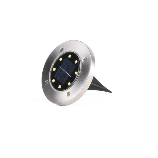 Runde LED-Solarlampe mit Edelstahlgehäuse und acht sichtbaren LEDs um ein zentrales Solarpanel. Die Lampe ist schräg fotografiert und mit einem schwarzen Erdspieß ausgestattet.