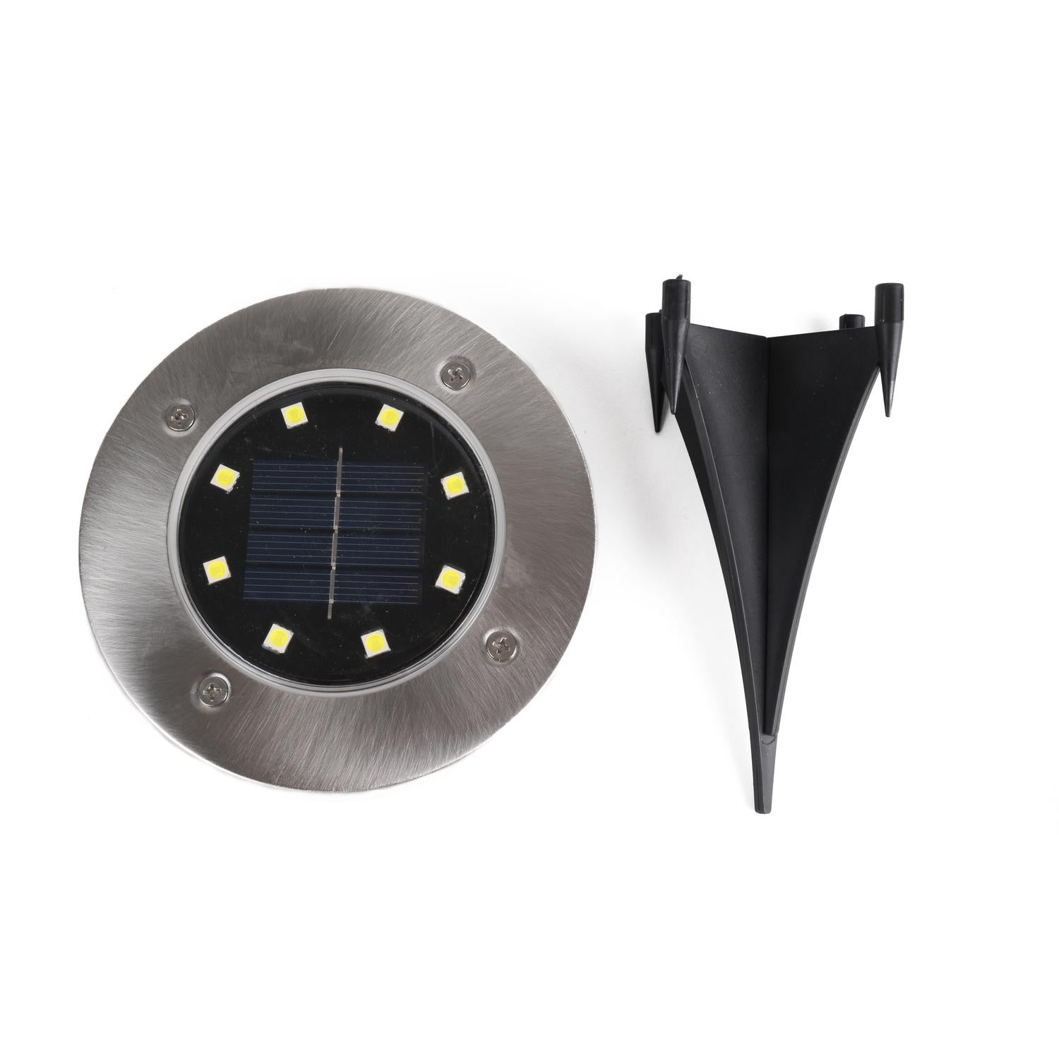 Solarlampe und Erdspieß separat nebeneinander auf weißem Hintergrund dargestellt. Die runde Lampe zeigt acht LEDs um das mittig platzierte Solarpanel, der Erdspieß ist schwarz und dreizackig geformt.