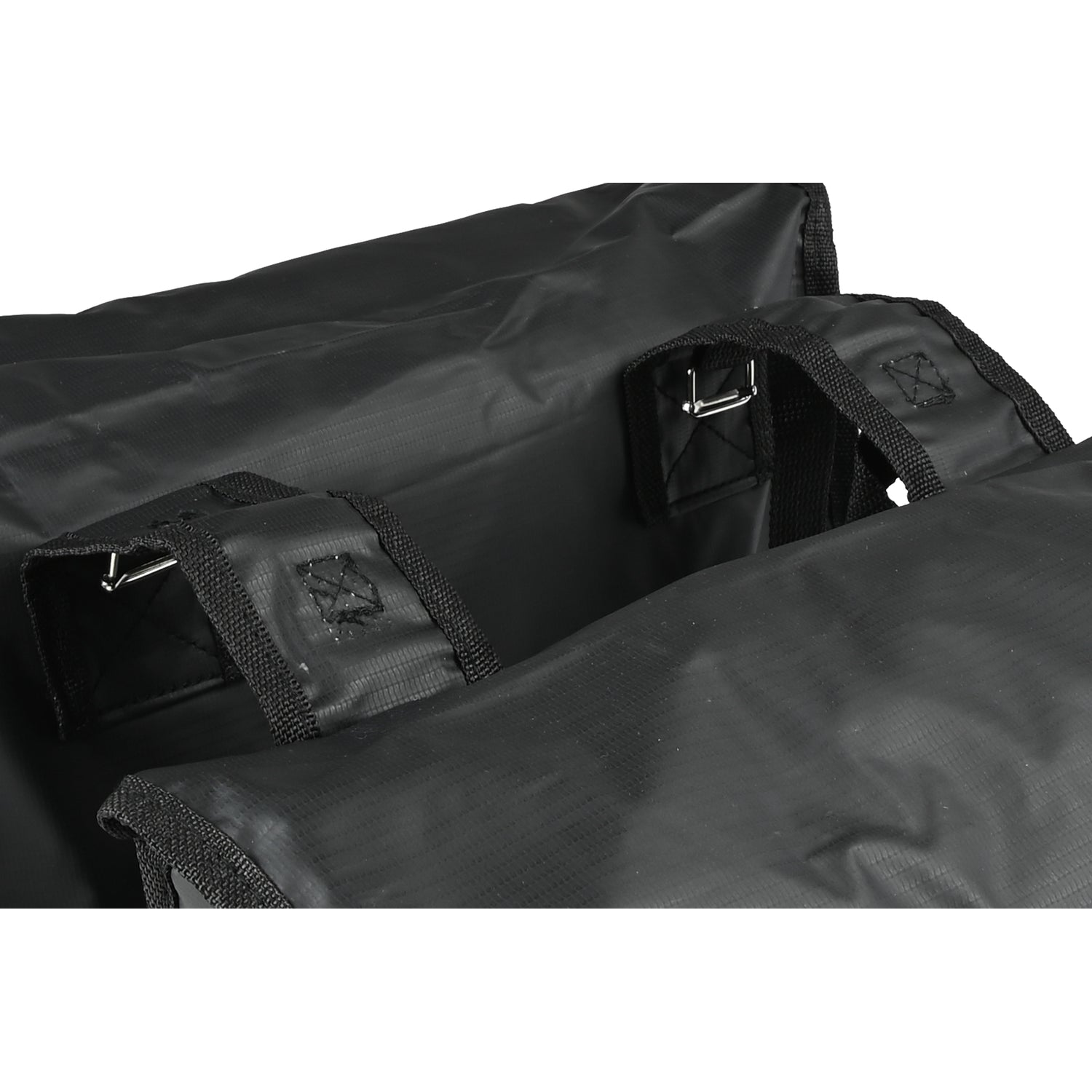 Nahaufnahme der oberen Befestigungsschlaufen einer schwarzen doppelseitigen Fahrradtasche mit Metallstiften.