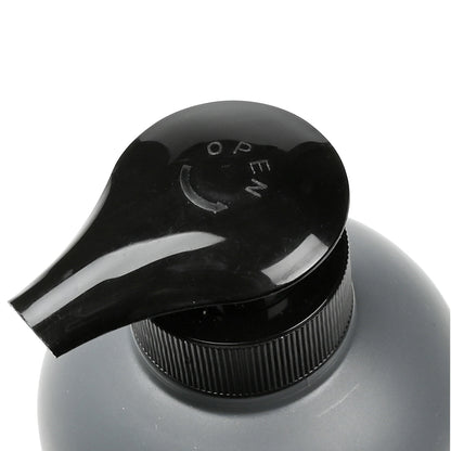 Nahaufnahme des schwarzen Pumpkopfes eines Seifenspenders mit Aufschrift „OPEN“ und Pfeilmarkierung.