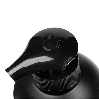 Nahaufnahme des schwarzen Pumpkopfes eines Seifenspenders mit Aufschrift „OPEN“ und Pfeilmarkierung.