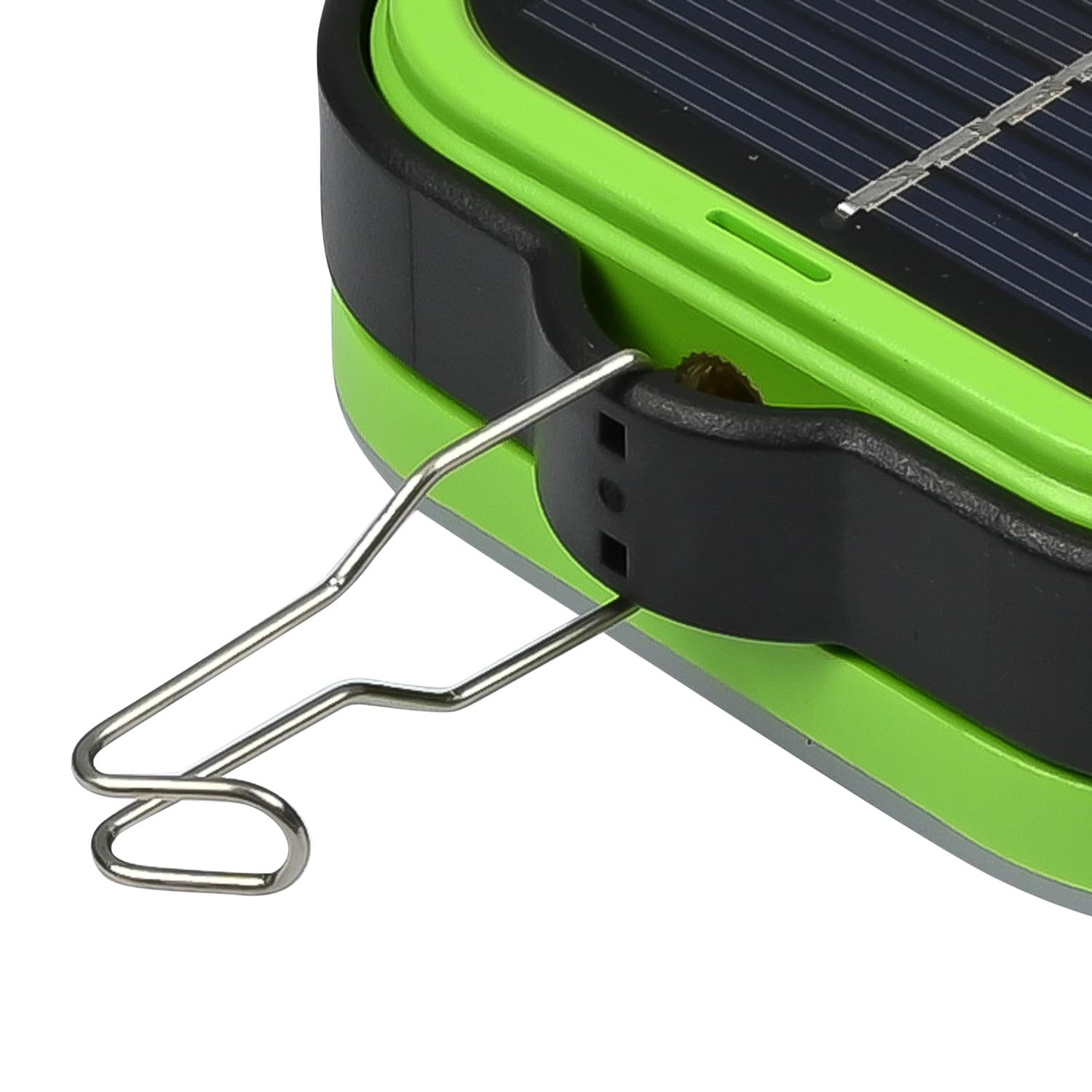 Detailansicht eines grünen Campinglichts mit schwarzem Gehäuserand, ausgeklapptem Metallhaken und sichtbarer Solarzelle, seitlich und nah aufgenommen vor weißem Hintergrund.
