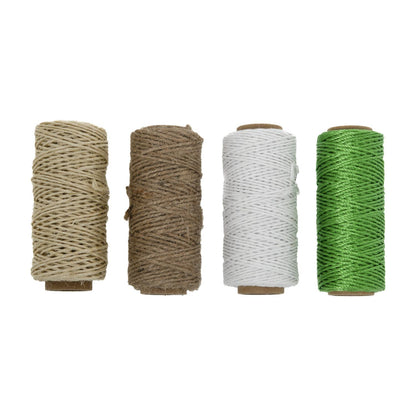 Vier Garnrollen aus Karton mit aufgewickelter Schnur in Beige, Braun, Weiß und Grün, nebeneinander stehend in gerader Reihe vor weißem Hintergrund.