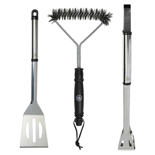 Drei Grillwerkzeuge nebeneinander: links ein Wender mit Schlitz, in der Mitte eine Reinigungsbürste mit schwarzem Griff und rechts eine Grillzange mit gezacktem Greifer. Alle Griffe sind aus Edelstahl mit schwarzer Kunststoffauflage.