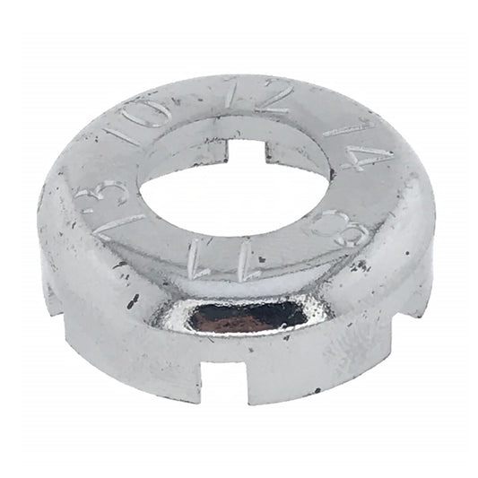 Rundes, silberfarbenes Metallwerkzeug mit zentraler Öffnung, mehreren rechteckigen Aussparungen am Rand und eingravierten Zahlen auf der Oberseite, auf weißem Hintergrund.