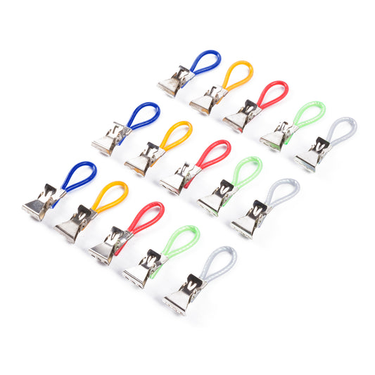 Fünfzehn Handtuchhalter-Clips aus Metall mit gummierten Schlaufen in Blau, Gelb, Rot, Grün und Grau, schräg angeordnet auf weißem Hintergrund.