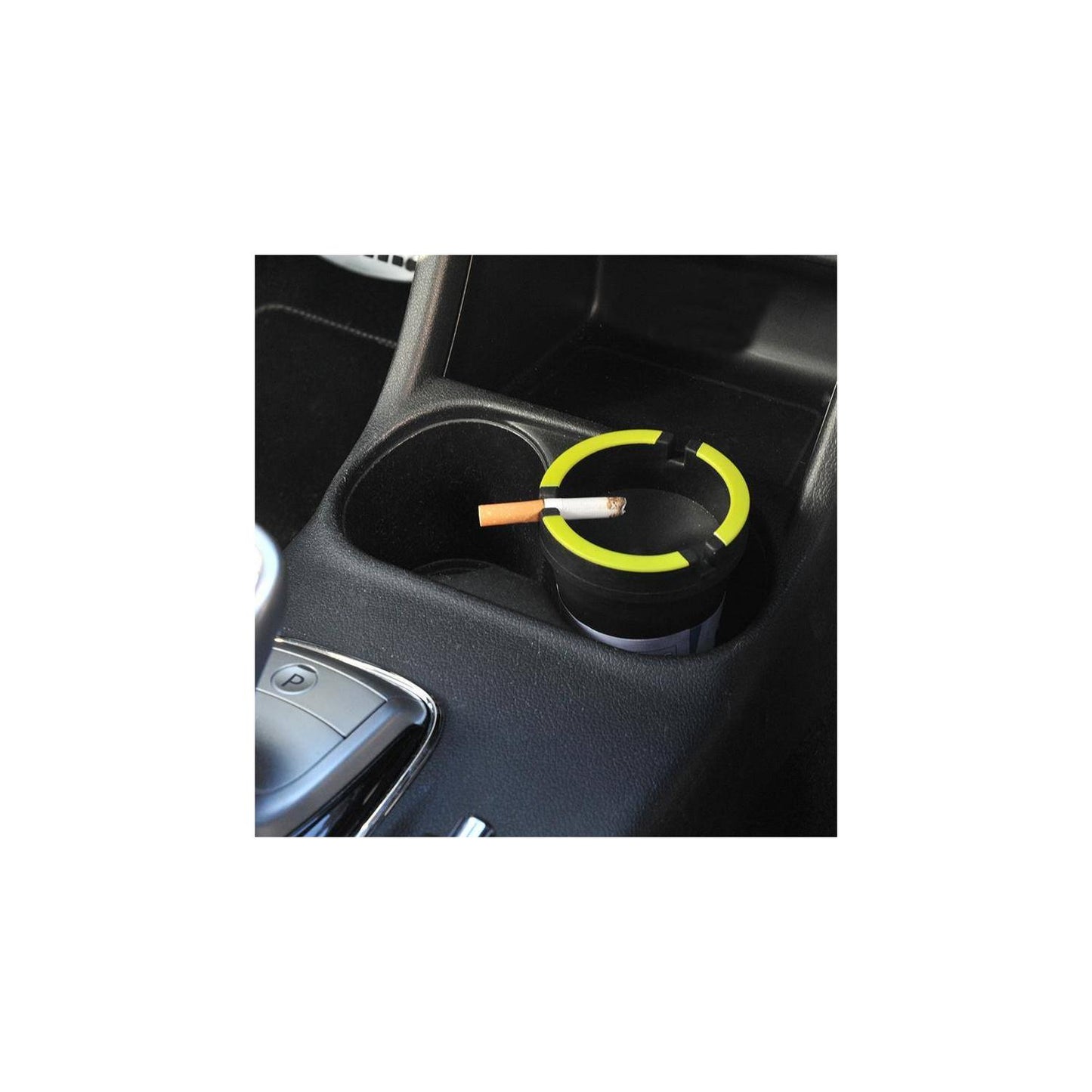 Schwarzer Autoaschenbecher mit grünem Rand in der Mittelkonsole eines Fahrzeugs, mit einer Zigarette im Aschenbecherschlitz.